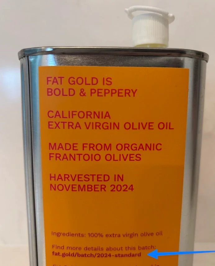 A can of olive oil with fat.gold domain name on it