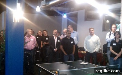dt-1 DomainTools CEO Tim Chen addresses a crowded open house event in the new Seattle office, discussing the company's vision and the features of their updated workspace while attendees listen intently.