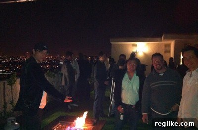 Ammar Kubba, smiling, at an informal rooftop gathering at night.