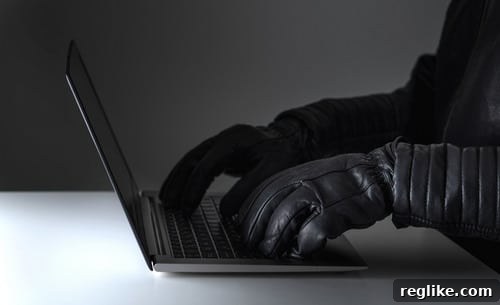 445.com Faces Domain Theft Lawsuit 2 A person appearing to be a thief at a laptop computer, engaged in cybercrime related to digital assets or domain theft.
