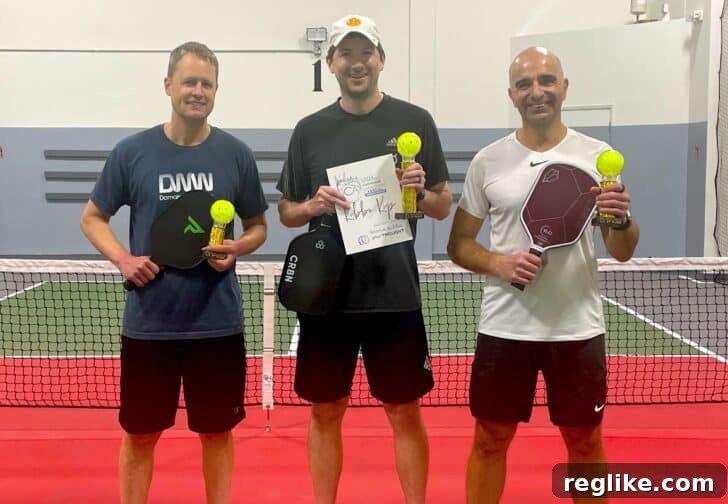 ICA Las Vegas: The Insights You Need Now 2 Andrew Allemann, Steven Kennedy, Ammar Kubba holding pickleball trophies standing on a pickleball court.