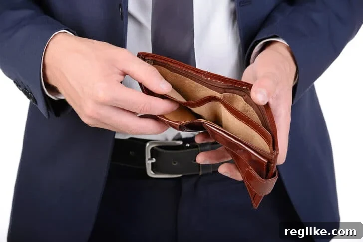 Man in a suite opening his wallet with nothing in it.