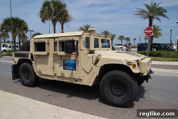 A robust Humvee vehicle, parked on a paved surface with a clear sky in the background, symbolizing its rugged nature and association with military-grade vehicles.