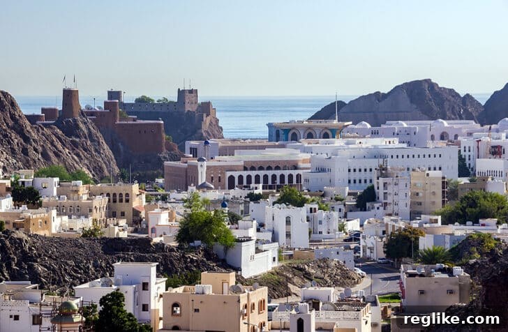 ICANN Adds Global Destinations: Seville, Muscat, Vancouver 2 Muscat, Oman'da dağlar ve gökyüzü fonunda modern bir bina. Bu yapı, bir kongre merkezini veya önemli bir toplanma noktasını andırıyor ve küresel bağlantı ile gelişmiş altyapıyı simgeliyor.